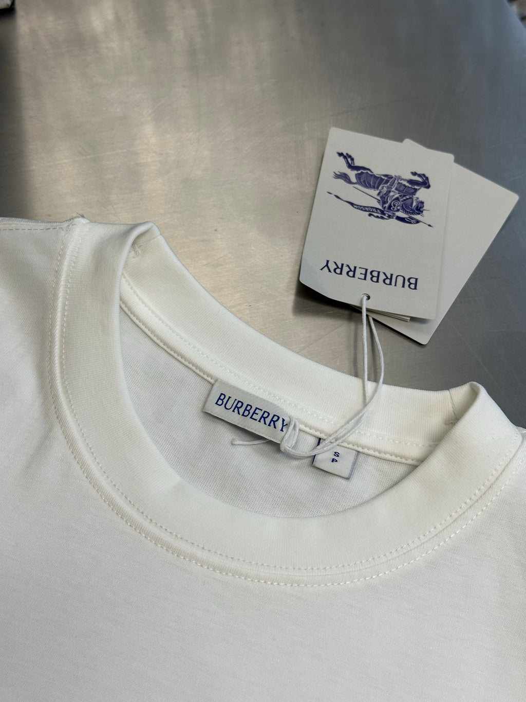 White crew-neck T-shirt with small Burberry neck label and attached tag
