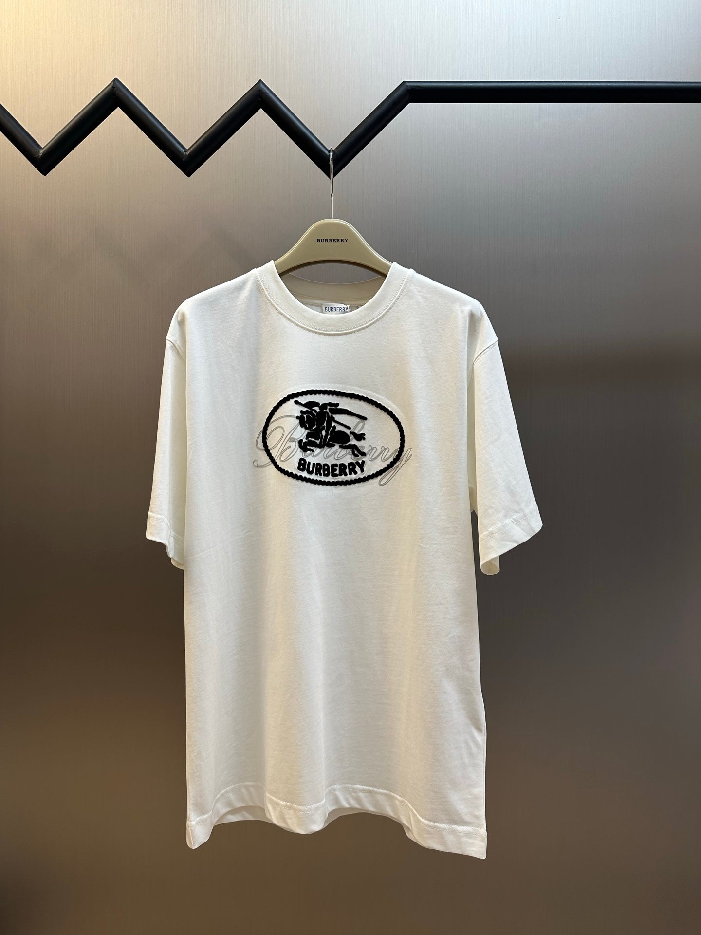 White T-shirt with black oval Burberry logo graphic on the chest