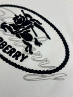 White Burberry oval logo T-shirt close-up, black stitched edging and sketch lines