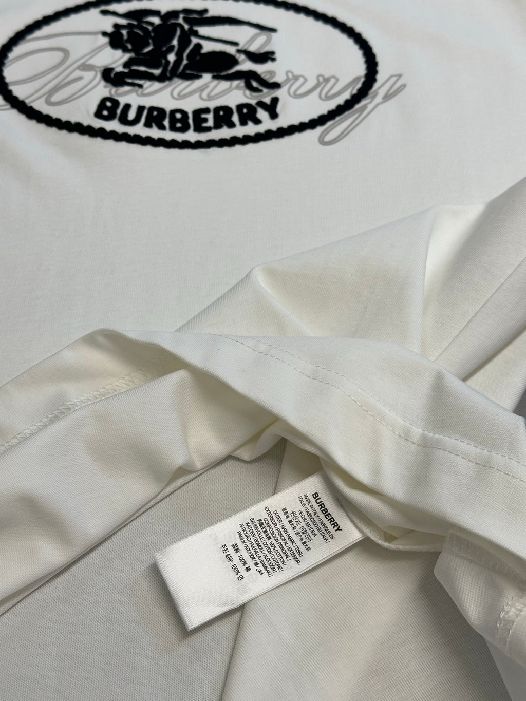 White Burberry T-shirt folded with oval logo on top, inner seam label visible