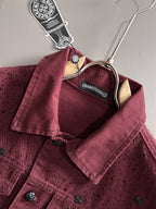 Maroon denim jacket with point collar and snap closure, studded fabric, front view on hanger