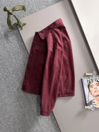 Maroon denim jacket hanging, long sleeves, studded front panels, snap pockets