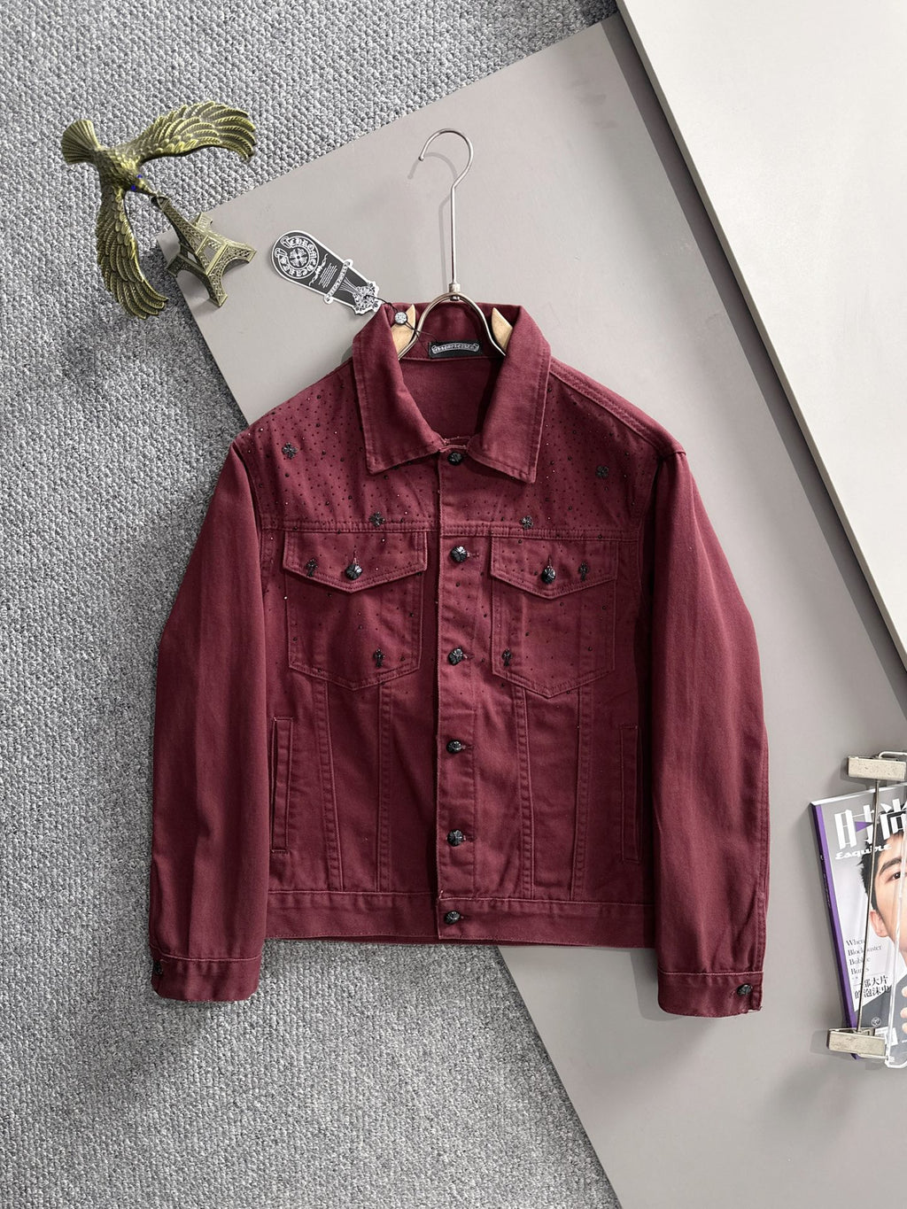 Maroon long-sleeve denim jacket on hanger, point collar, snap buttons, chest and pocket seams