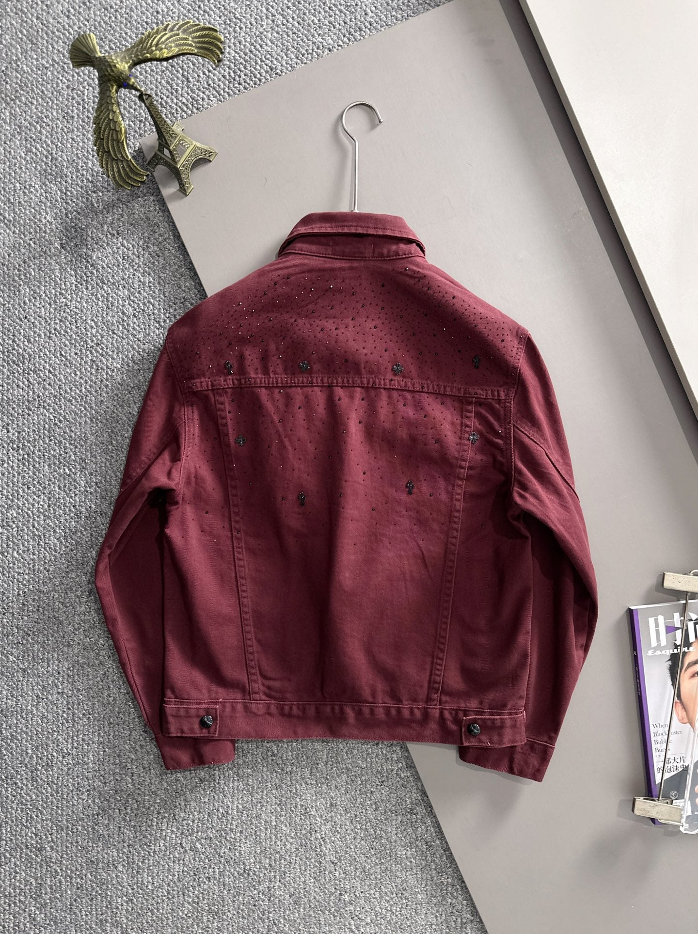 Maroon denim jacket back on hanger, long sleeves, snap buttons, studded texture