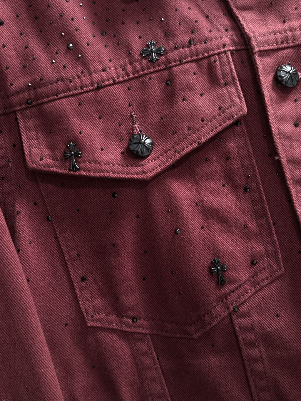 Maroon studded denim jacket detail, flap pockets and dark metal snap buttons