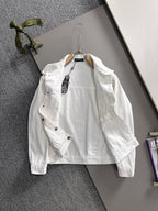 White denim jacket with black dot pattern, chest pockets, and button front on hanger