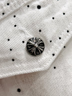 White denim fabric with black dot pattern and round black decorative button