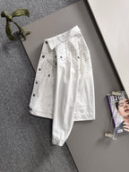 White denim jacket with black dot pattern and star patches, button front, long sleeves