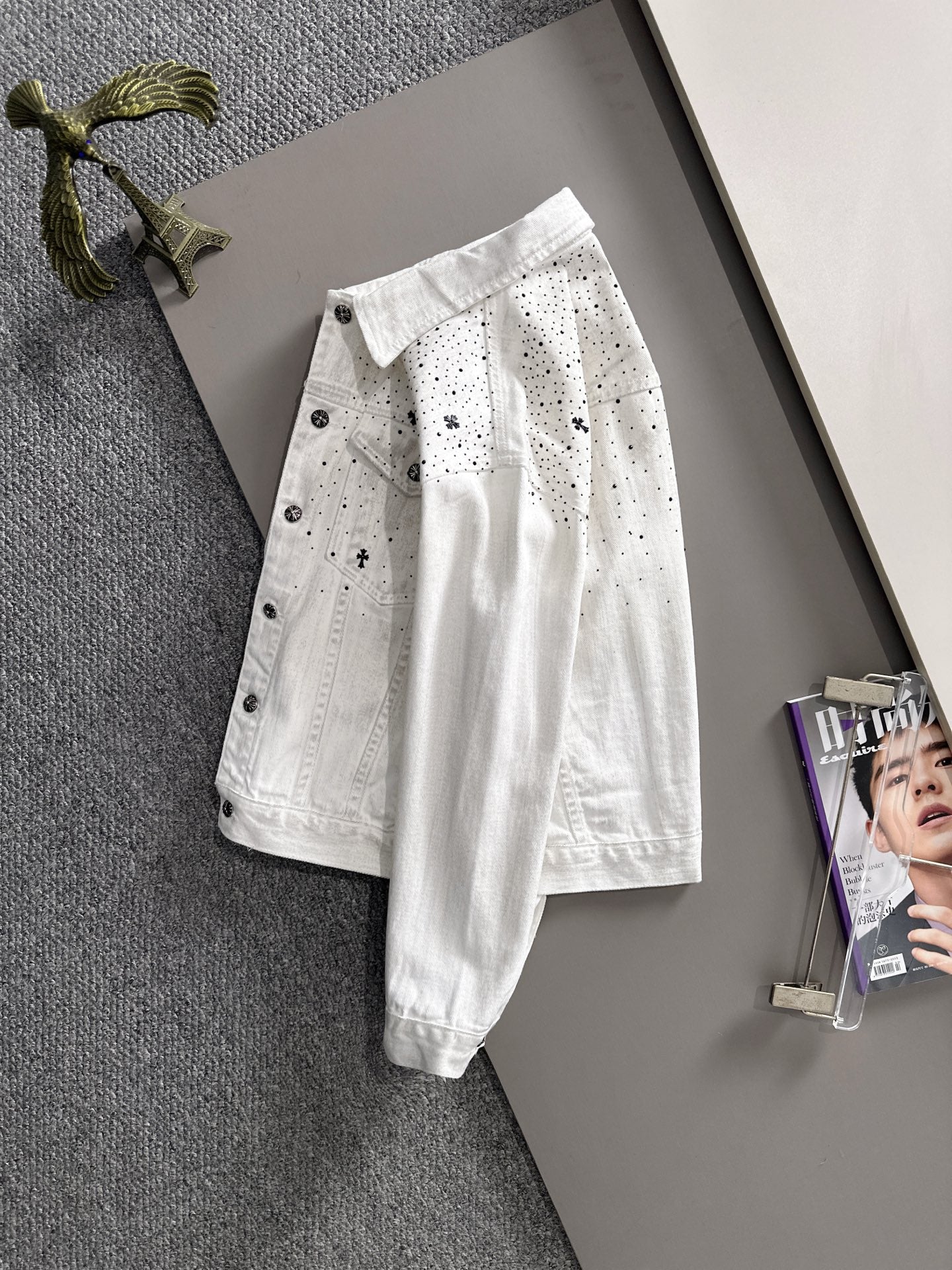 White denim jacket with black dot pattern and star patches, button front, long sleeves