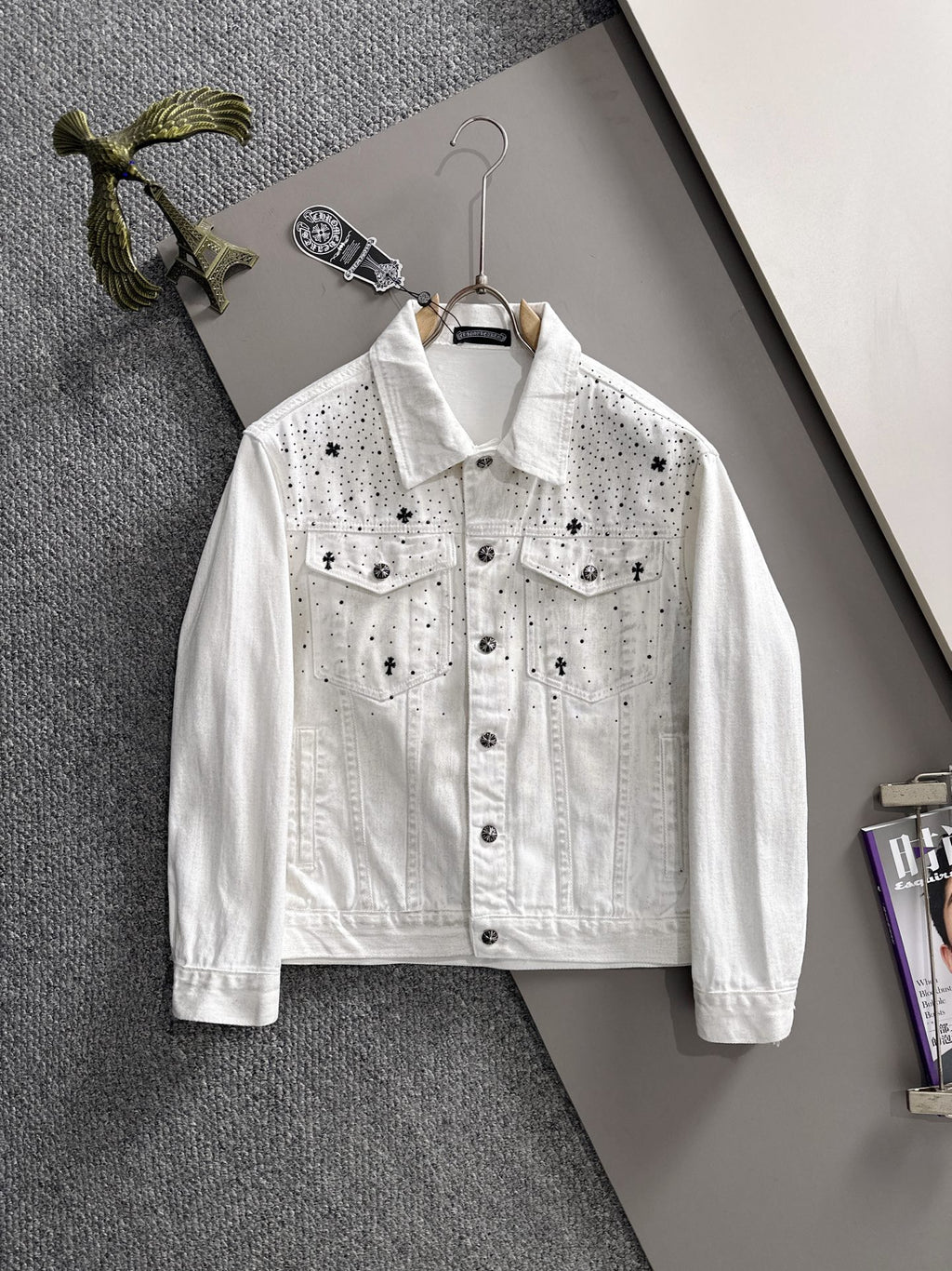 White denim jacket with black star-and-dot embroidery, button front, chest flap pockets