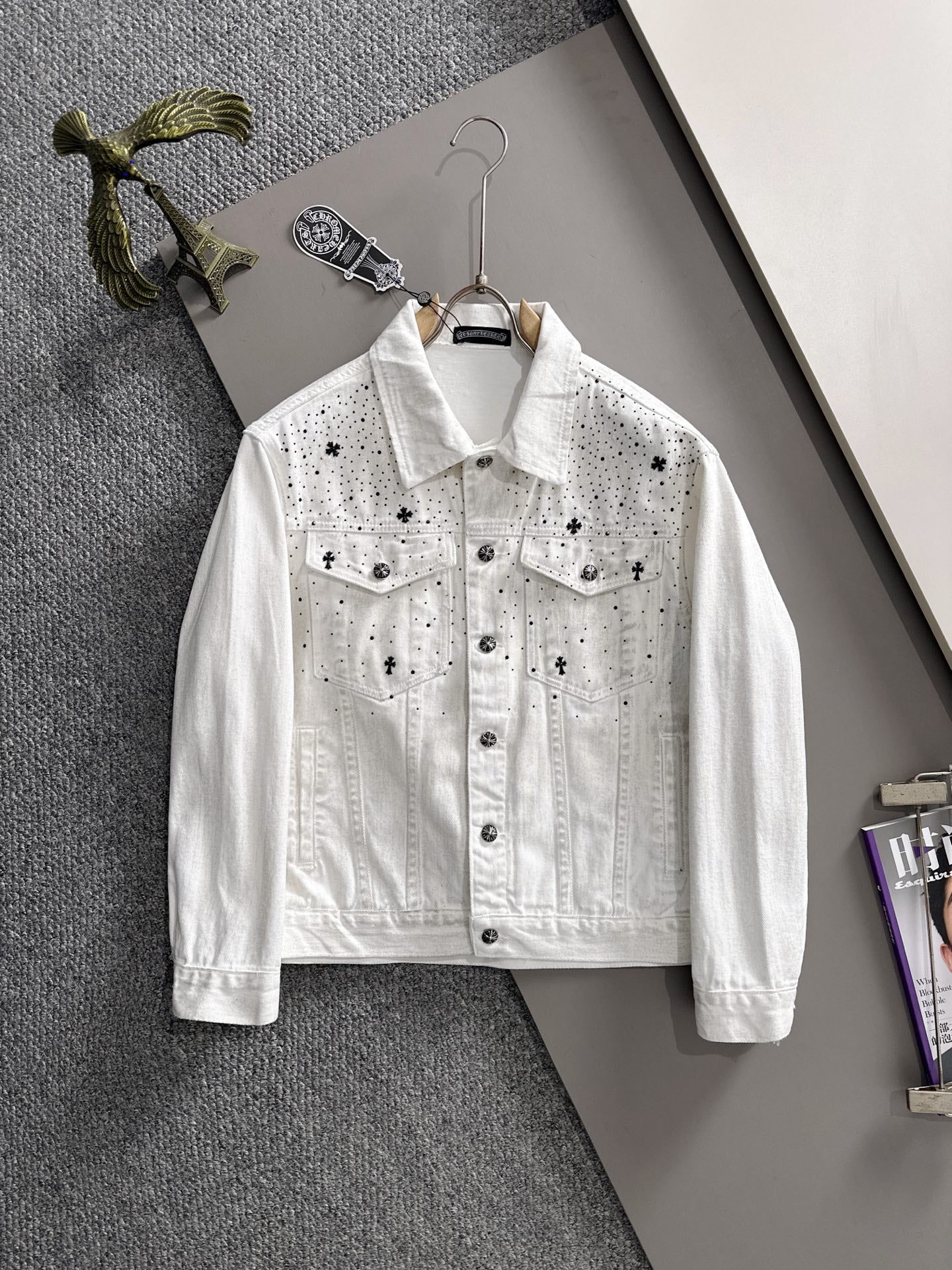 White denim jacket with black star-and-dot embroidery, button front, chest flap pockets