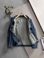 Blue long denim jacket laid flat on hanger with front graphic panels