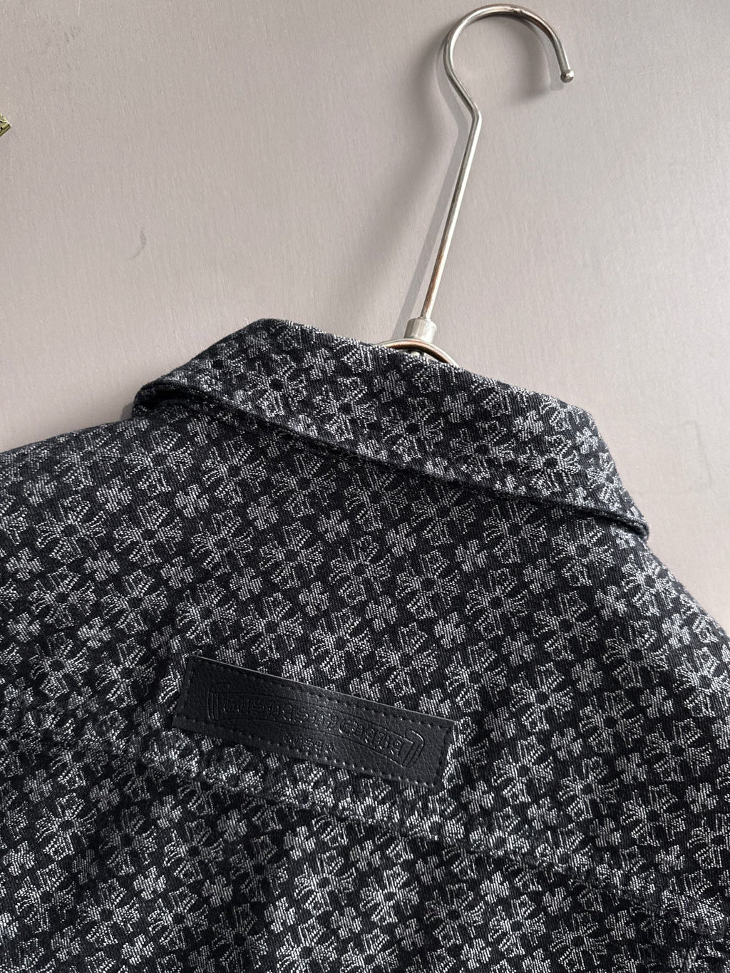 Back of patterned long-sleeve jacket on hanger with wide collar
