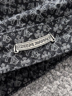 Close-up of patterned jacket fabric and metal brand-style logo patch