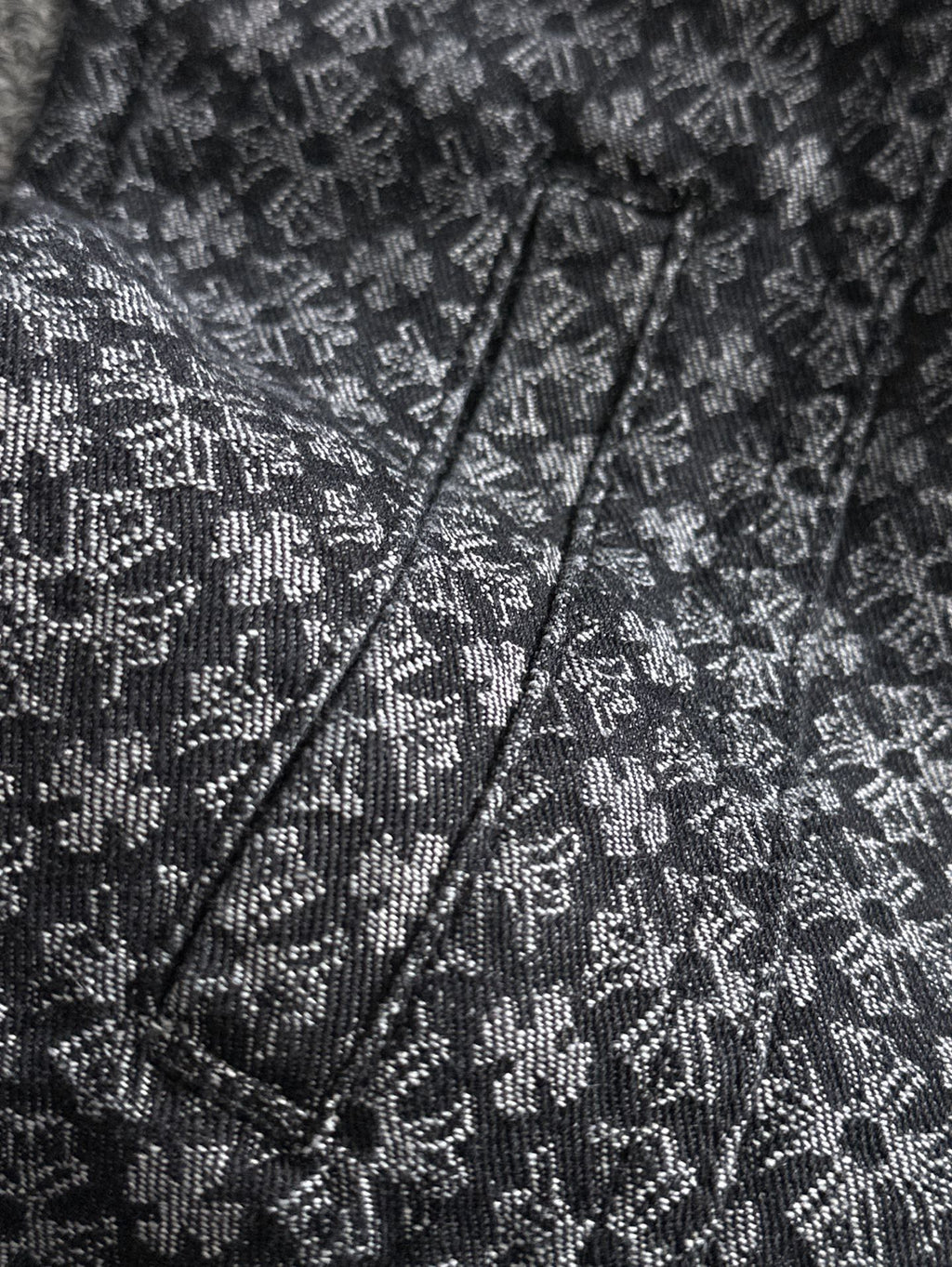 Close-up of patterned jacket front with V-neck placket and stitched seams