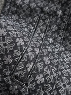 Close-up of patterned jacket front with V-neck placket and stitched seams