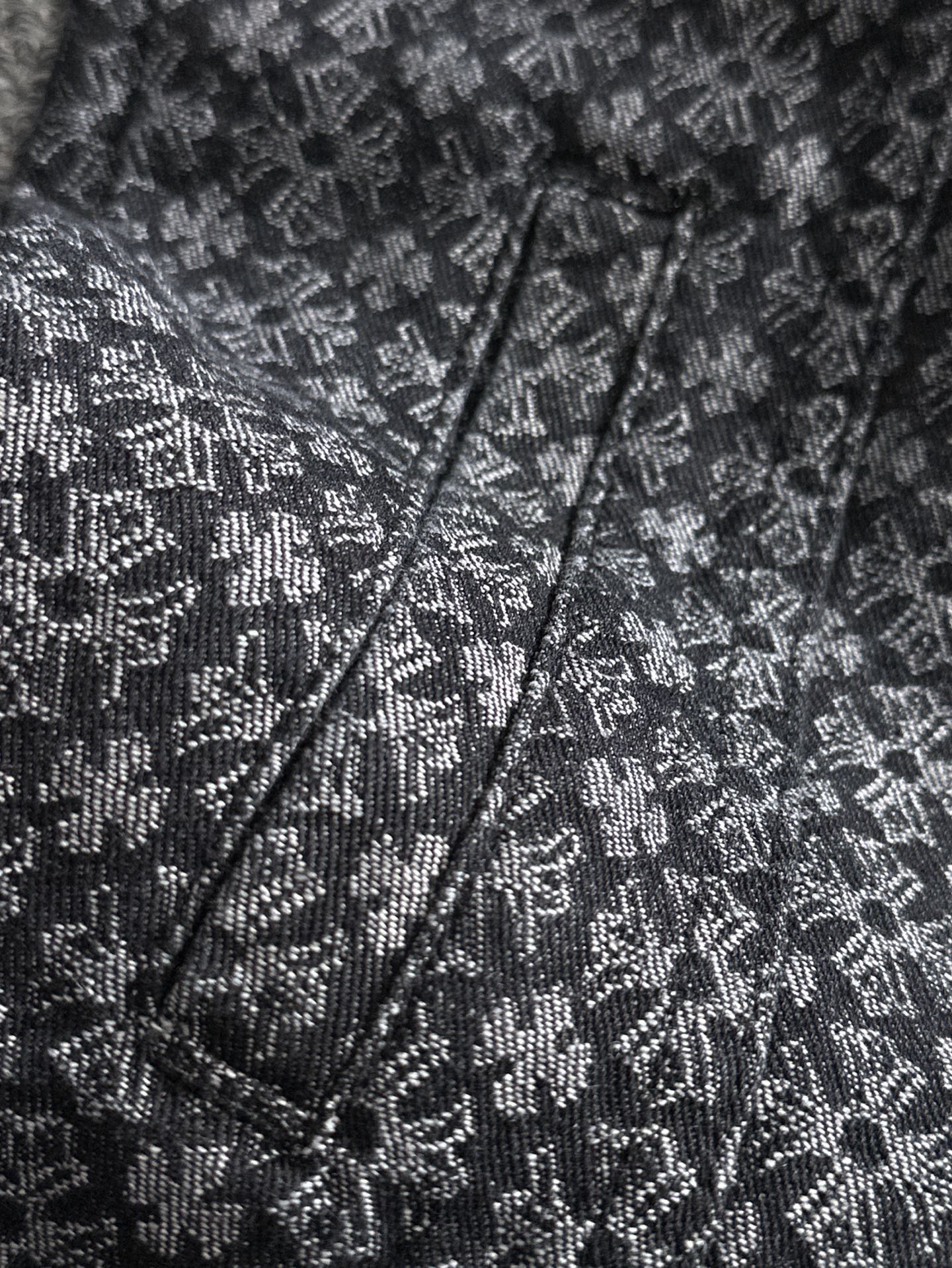 Close-up of patterned jacket front with V-neck placket and stitched seams