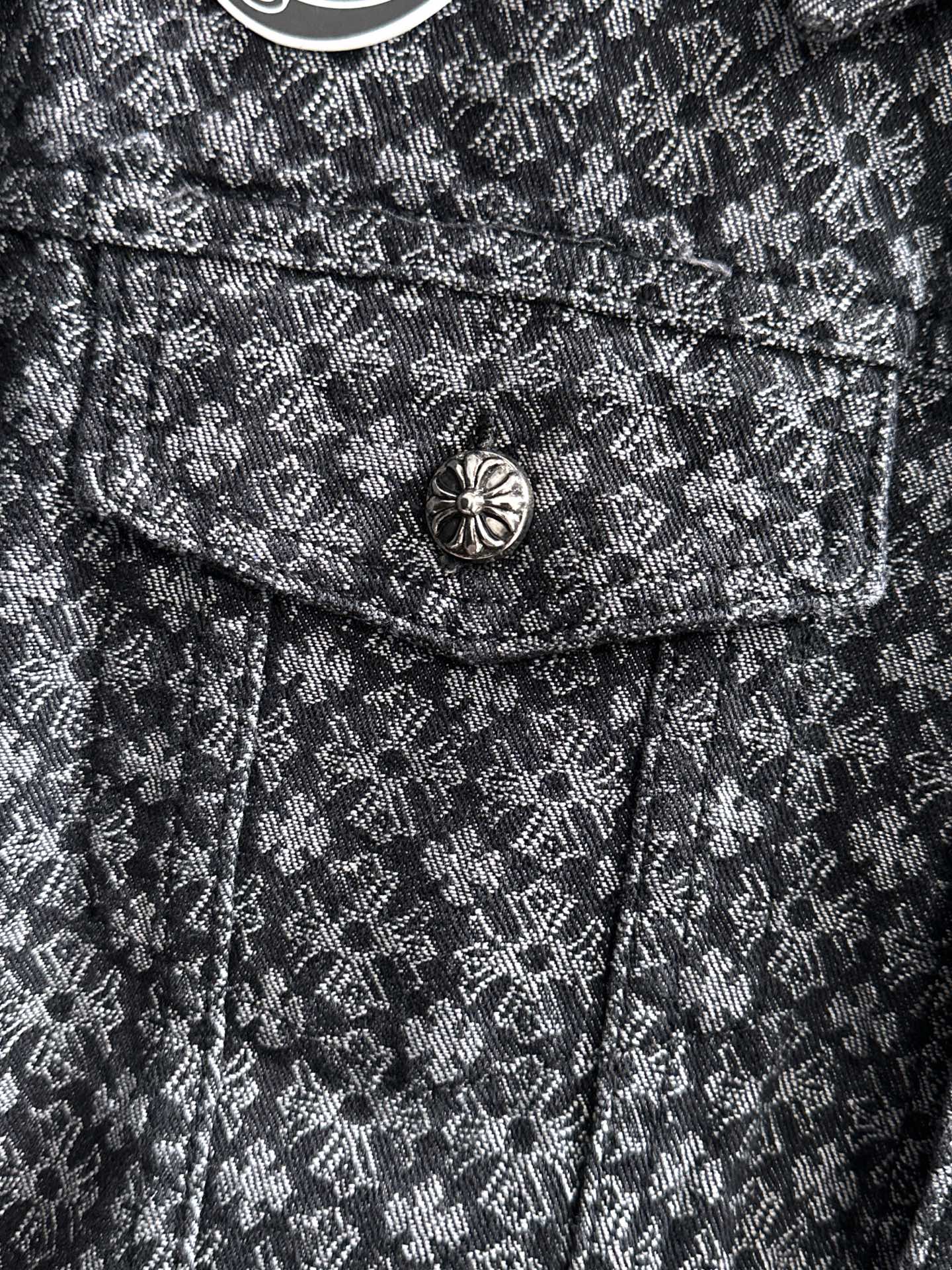 Close-up of jacket chest flap and round button on patterned fabric