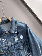 Blue denim jacket with embroidered cross patch and scalloped collar detail