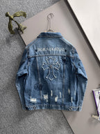 Blue denim jacket back with bold cross embroidery and distressed wash
