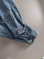 Blue denim jacket sleeve cuff with embroidered cross badge and button