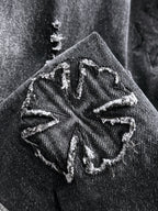 Dark denim jacket shoulder patch with stitched graphic and worn distressed texture