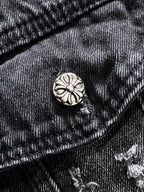 Dark denim jacket pocket flap with round metal button and embroidered details