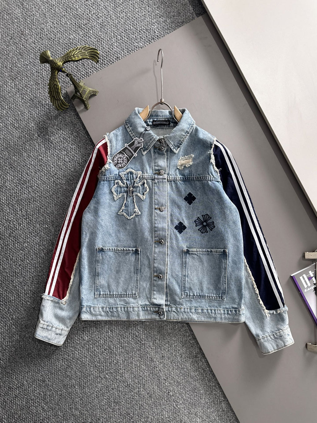Light blue denim long-sleeve jacket with front button closure and embroidered patches
