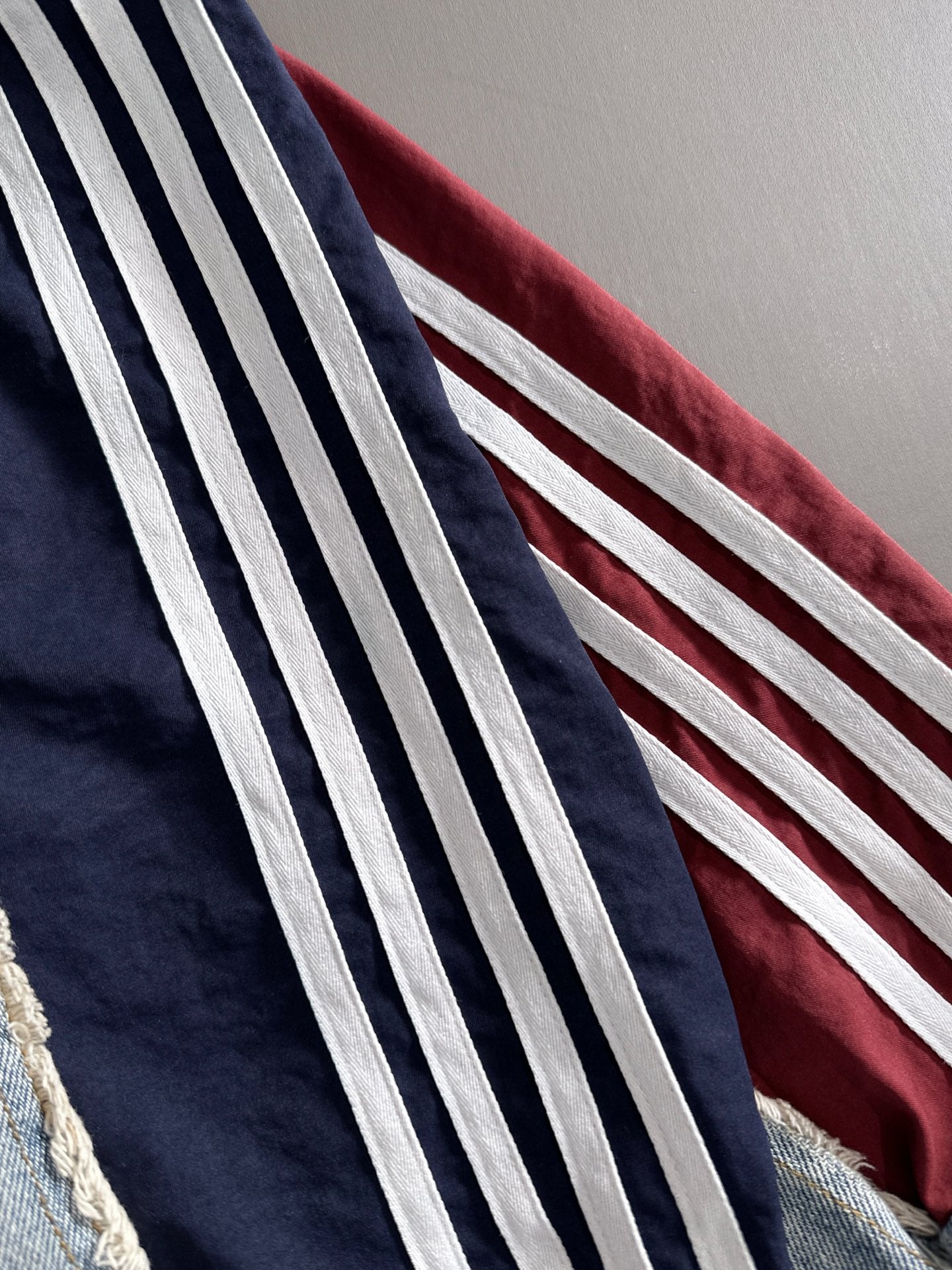 Denim jacket sleeve with bold navy and white striped side panel detail