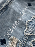 Close-up denim jacket with white embroidered text and small dark square patches