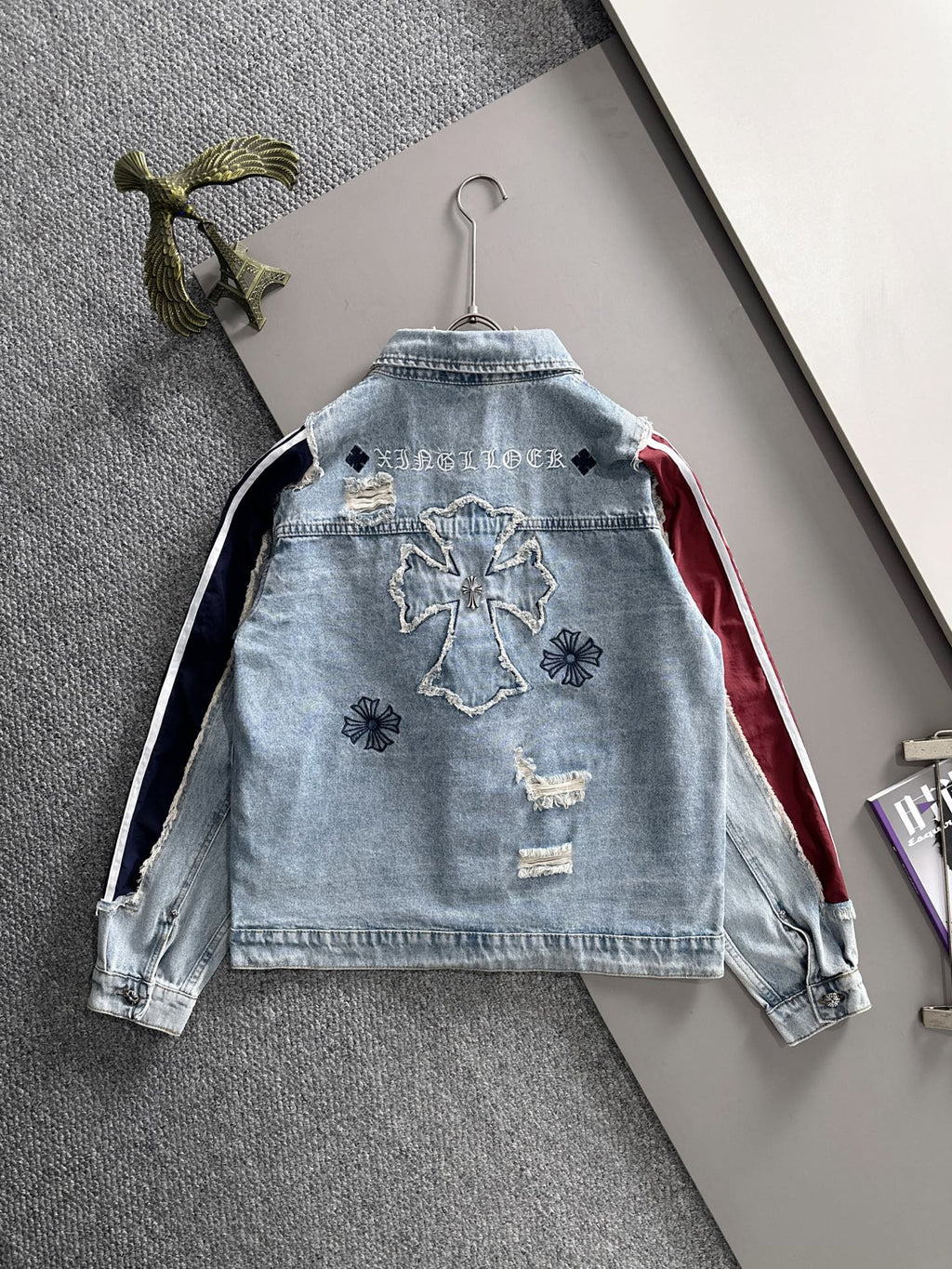 Light blue denim jacket back with embroidered motifs and navy-and-white stripe side panels