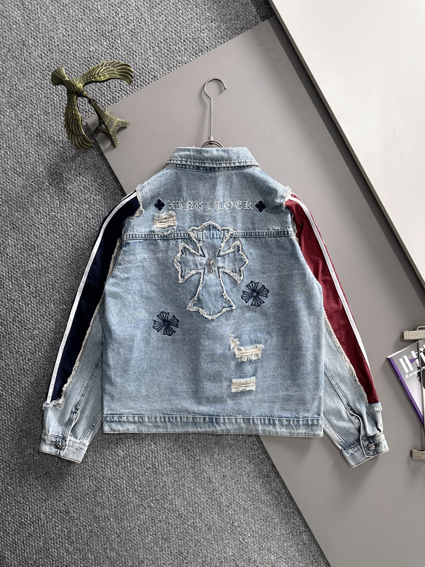 Light blue denim jacket back with embroidered motifs and navy-and-white stripe side panels