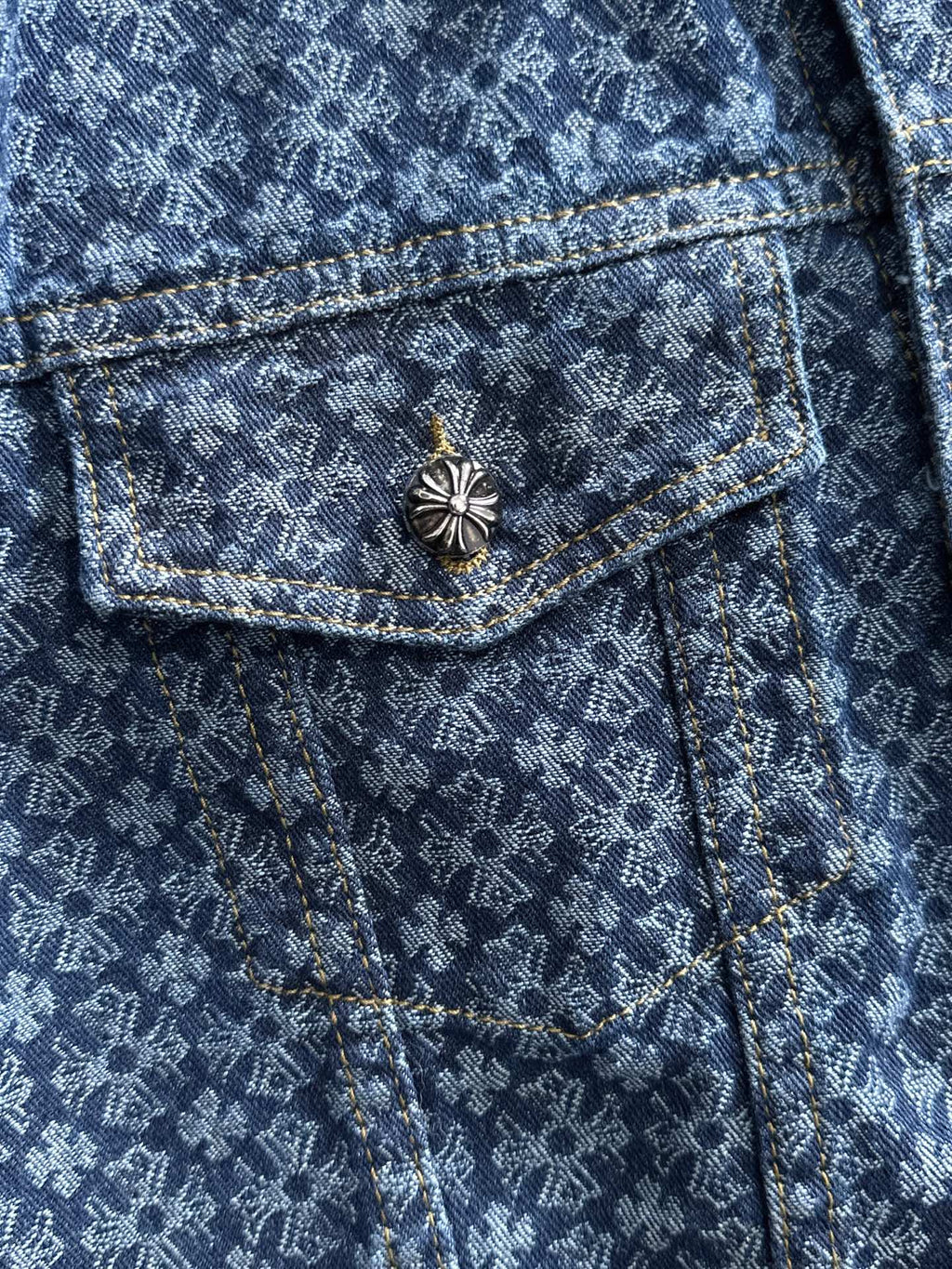 Blue patterned denim jacket with chest flap pocket and decorative flower button