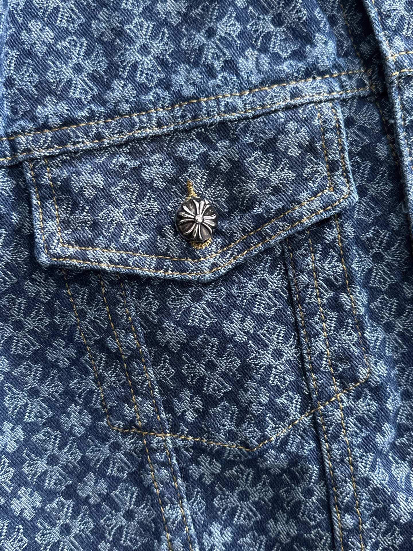 Blue patterned denim jacket with chest flap pocket and decorative flower button