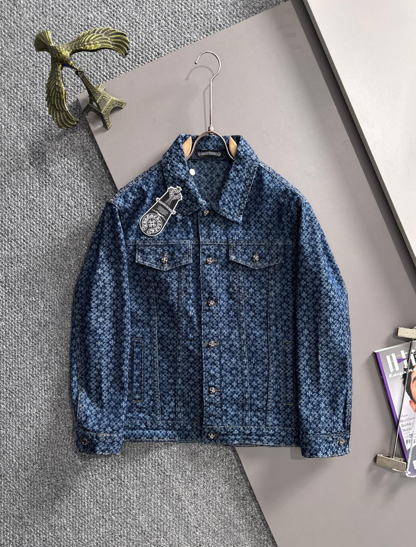 Blue long-sleeve denim jacket with allover pattern and button front, on hanger