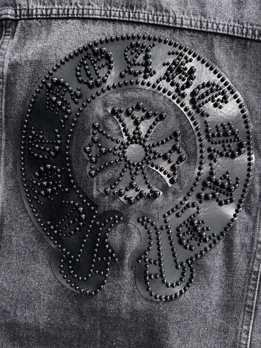 Large ornate studded back patch close-up with circular design on dark denim