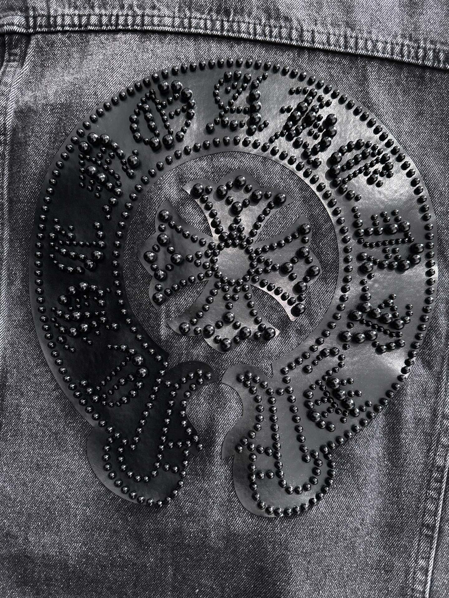 Large ornate studded back patch close-up with circular design on dark denim