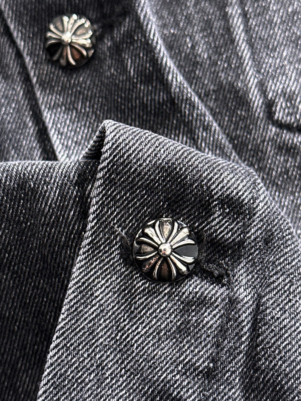 Denim jacket lapel and inner collar with metal flower button and patterned trim