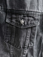 Dark denim jacket close-up of front pocket with small studded flower button detail