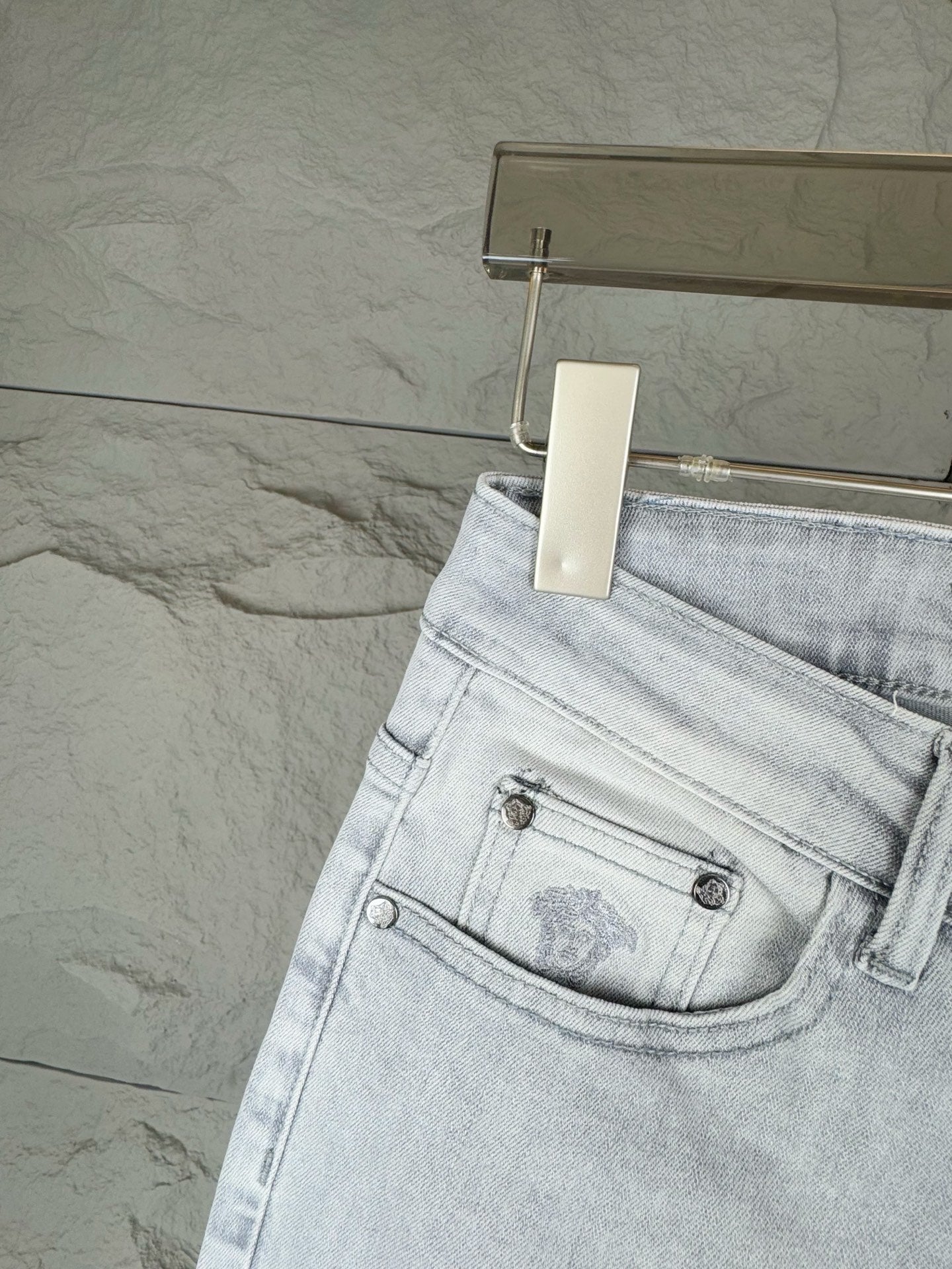 Light-wash denim jeans with back waist patch and metal button details