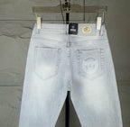 Light blue denim jeans front view with two front pockets and Versace tag