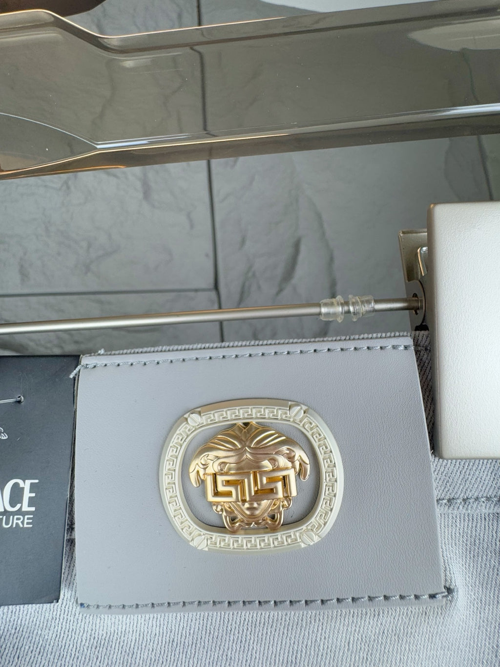 Versace accessory tag with gold emblem and light blue leather card