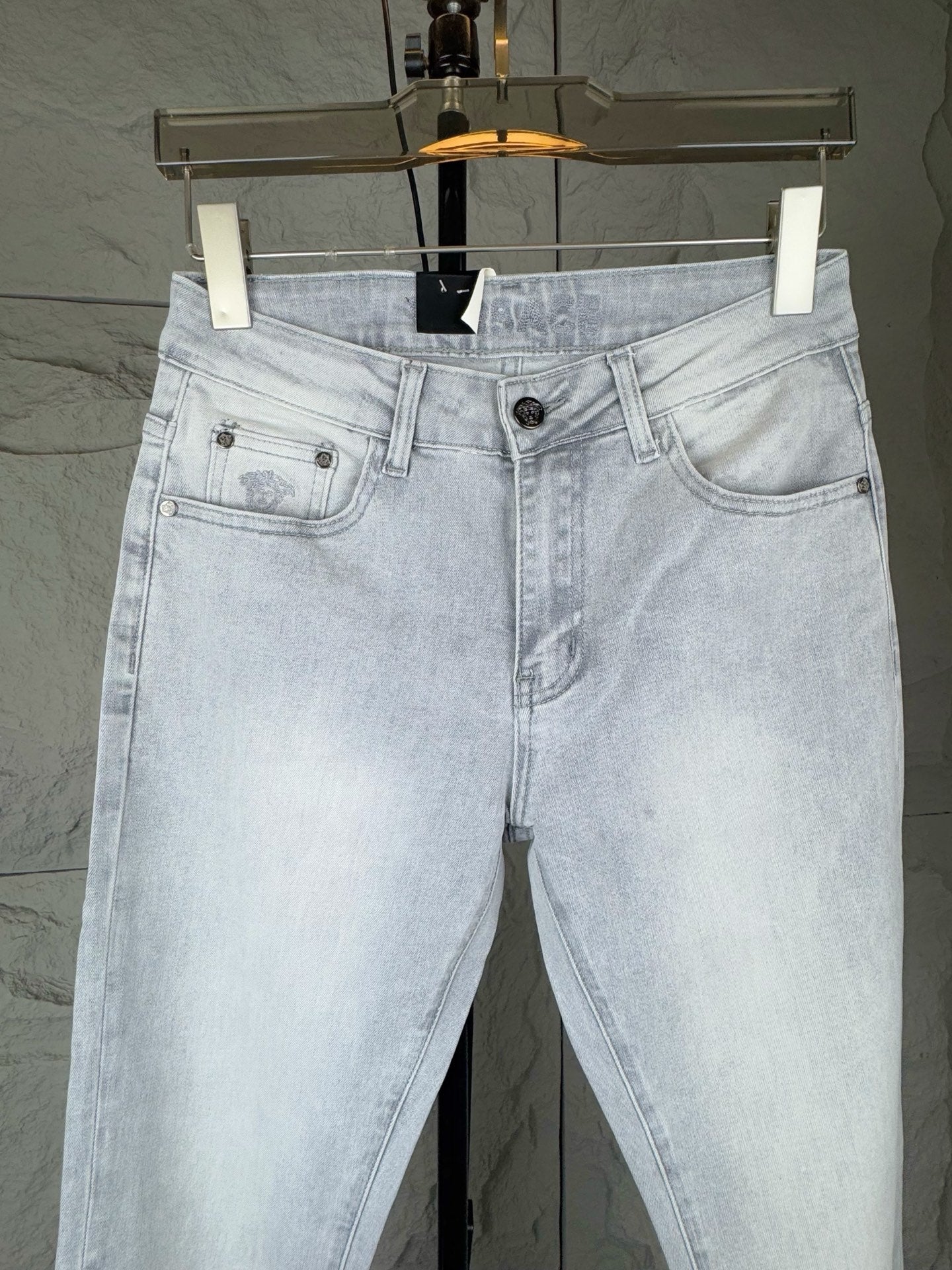 Light blue denim jeans front view with belt loops and buttoned pockets