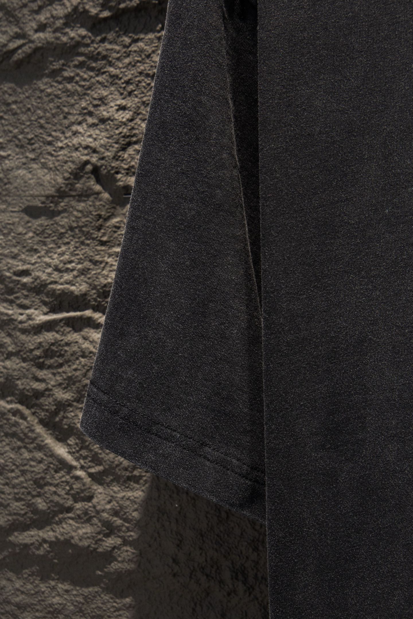 Black T-shirt side view with hem and sleeve opening