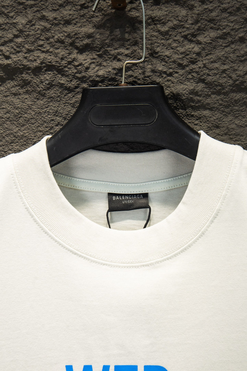 White Balenciaga T-shirt collar with inner brand tag, hanging on hanger