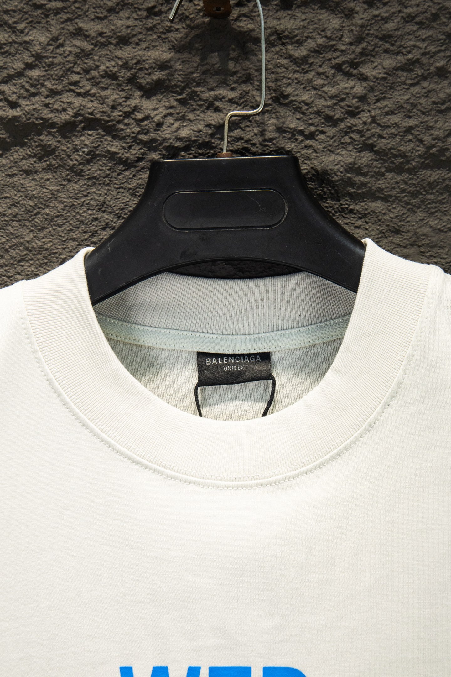 White Balenciaga T-shirt collar with inner brand tag, hanging on hanger