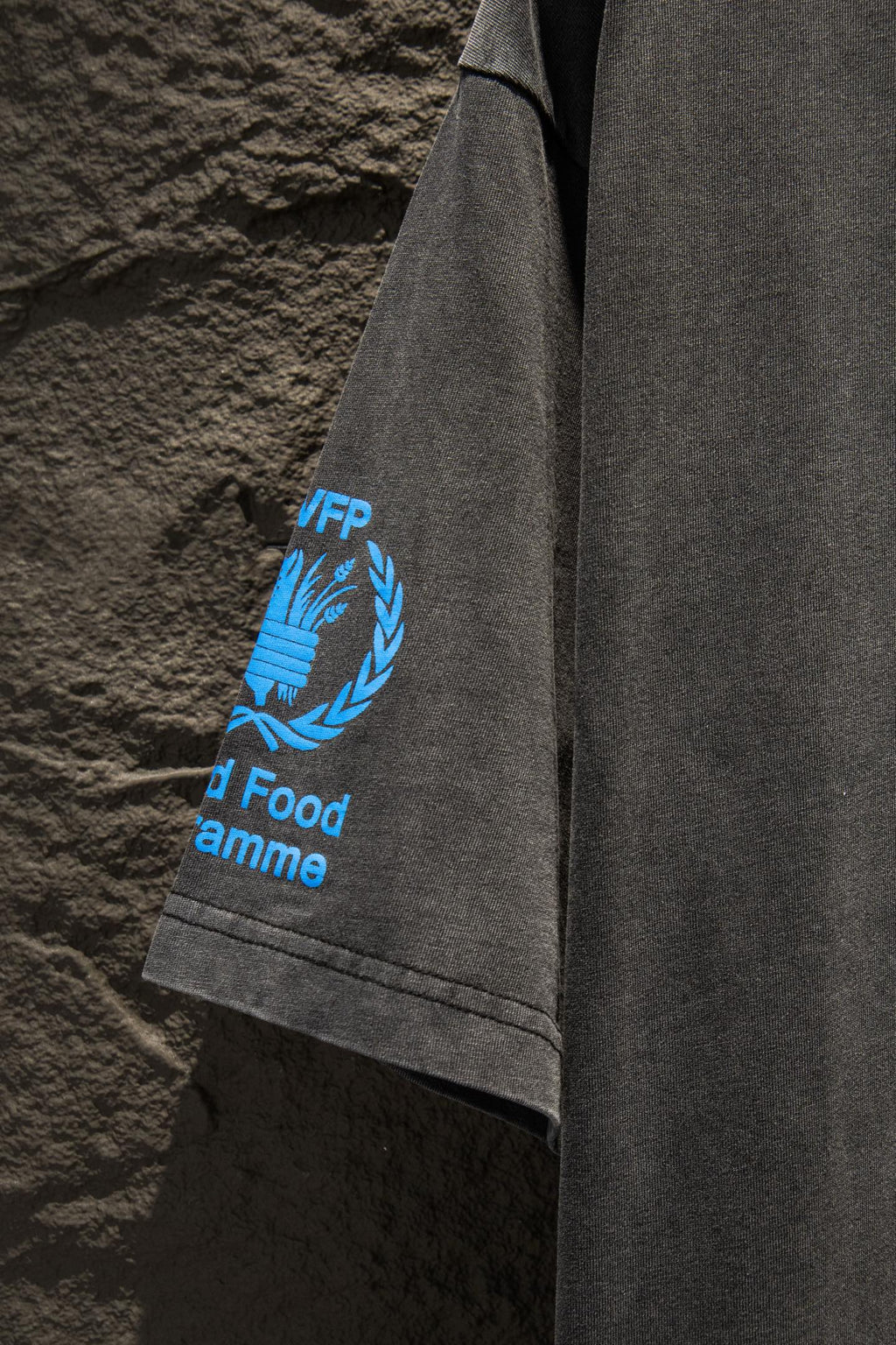 Gray T-shirt side view showing blue WFP laurel graphic and “World Food Programme”