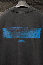 Gray T-shirt back with dense blue text and “BALENCIAGA” near hem