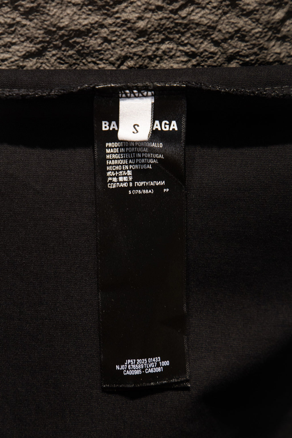 Black T-shirt inner neck label with product and care information text