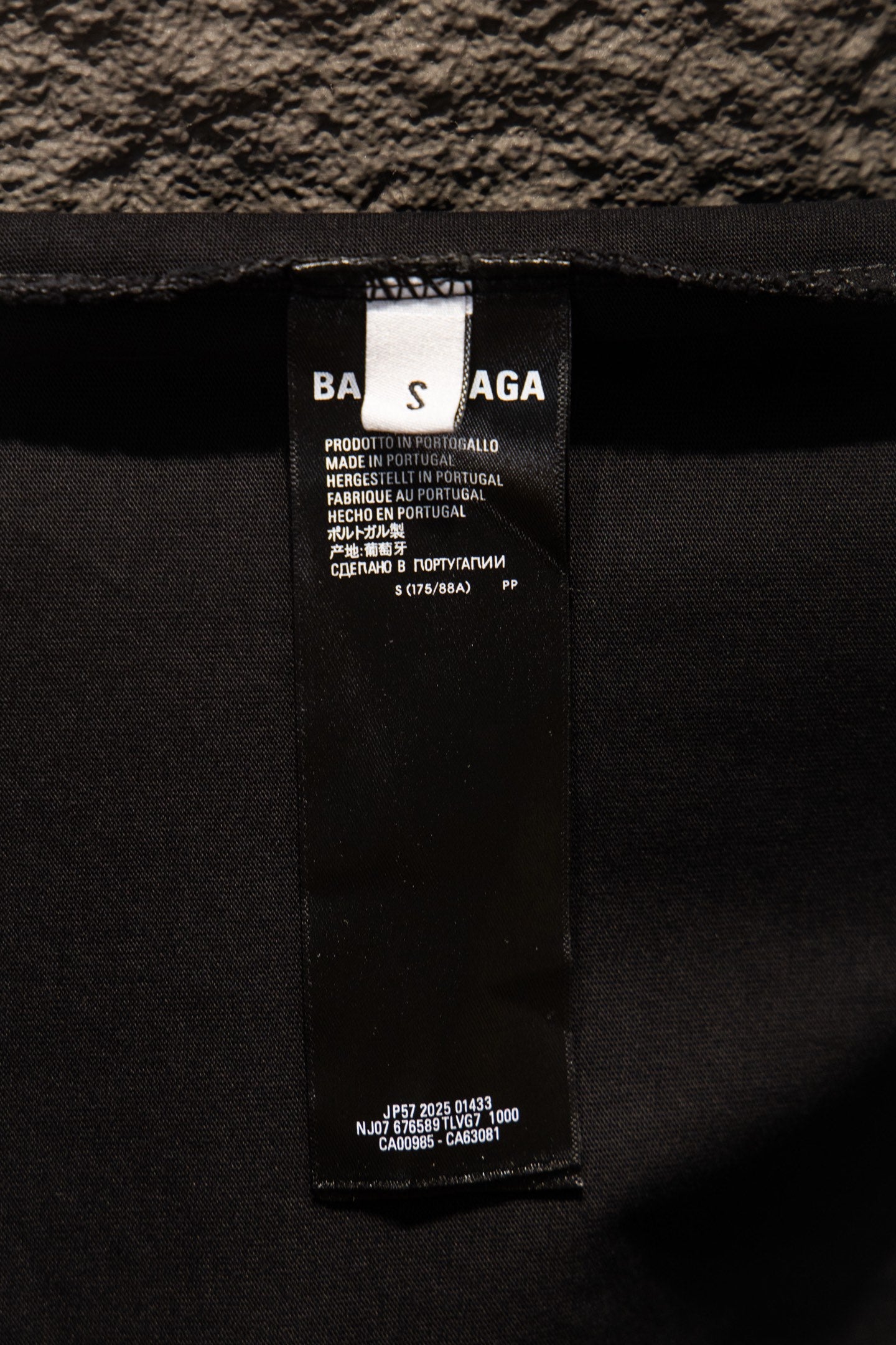 Black T-shirt inner neck label with product and care information text
